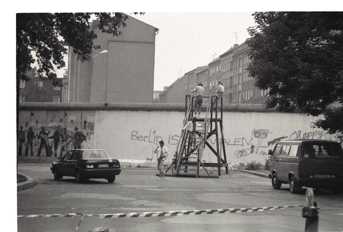 „Painting the Berlin Wall Gray“ Thomas Eller, 1986 This book is presenting a project I did as a young art student at the age of 22 in December 1986 shortly before my forced dismission from art school in Berlin. On December 15, 1986 I entered the visa issuing office of the GDR in Berlin Kreuzberg at the Waterloo Ufer 5-7. There I was trying to obtain information on who to talk to in East-Berlin to get “permission” for my project to paint the Berlin Wall gray in Kreuzberg just behind Künstlerhaus Bethanien where it was the most colorfully painted by artists. The 1980s were the pivotal moment for the peace movement in Germany, when NATO strategy had just shifted from “Mutual Assured Destruction”, which served as an effective deterrent to any kind of nuclear war between the two super-powers, to “Flexible Response”, which included scenarios of limited nuclear warfare with a new generation of nuclear warheads. A likely territory was Germany. This book documents the project and the resulting Stasi-file (documents collected by the secret service of the GDR) with photographs and documents. I never obtained any official permission. Inasfar this project really is a document of failed communication in the political realm between an artist and a government. However on a symbolical level it realized an artistic aspiration to reach into societal realities. By the mid-80s there were many artists in Berlin that developed a frontier city magic of images of which the Berlin Wall was an integral part. Everyone had gotten used to the Wall and artists´ efforts were not directed towards tearing down the wall, but to establish themselves in the legacy of Westberlin. I took this for bigottry and cynicism. The goal of the project “Painting the Berlin Wall Gray” was to again bring to attention the scandal that was the Berlin Wall. To engage the administration of the GDR was in same parts naive, as it seemed necessary for the sincerety of the project. At that time I was not aware of Joseph Beuys´ proposal in 1964 (my birthyear) to raise the height of the Berlin Wall by 4 cm for “esthetical reasons”. What I shared with him however, was the motive of the project to make visible the scandalon of the Berlin Wall in the western part of the city. Only if that was achieved, so my thinking at the time, one would ever have the chance to seriously set this issue on the agenda again. The book will contain three texts: - introduction - text about historical circumstances (NATO double track decision, Easter Demonstrations, April 1986 - nuclear melt-down in Chernobyl - text about the art project